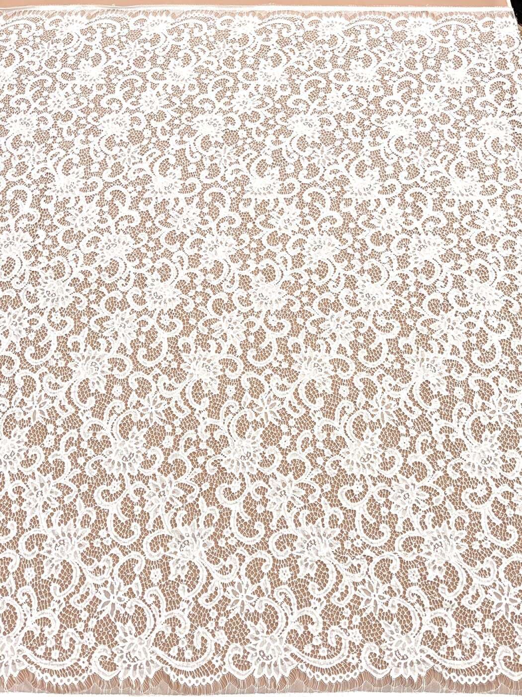 Ivory chantilly lace with pearls, beads and sequins, draped over blush