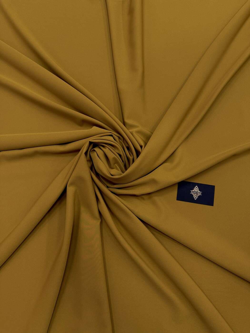 Mustard elastic crêpe swirled to show its matte drape