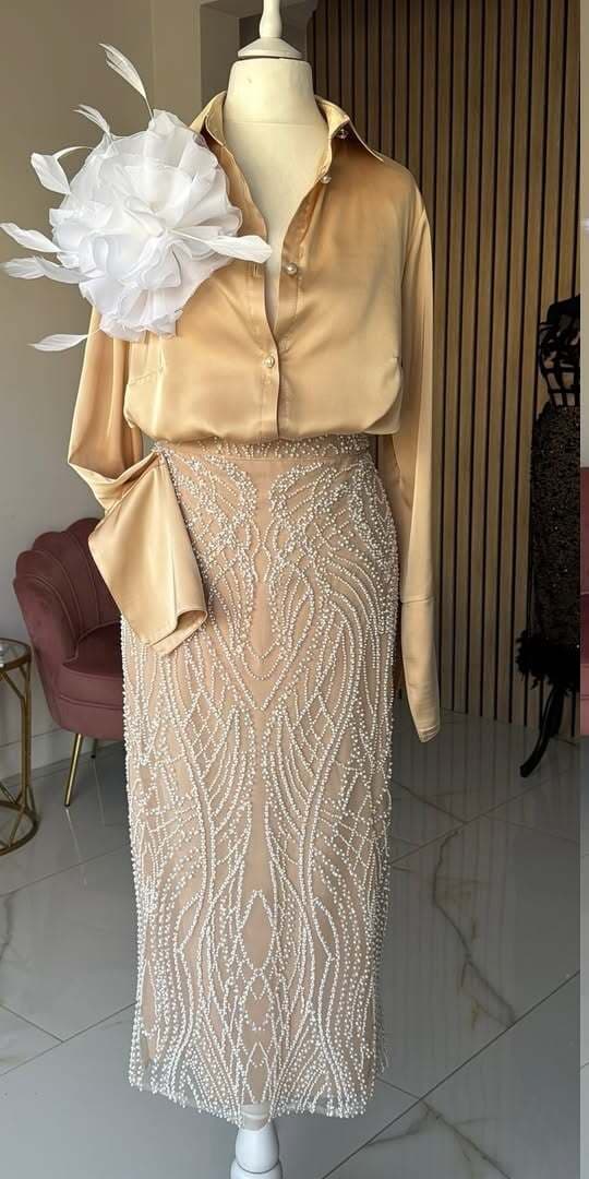 Gold satin blouse over an ivory pearl-beaded lace skirt, on a mannequin